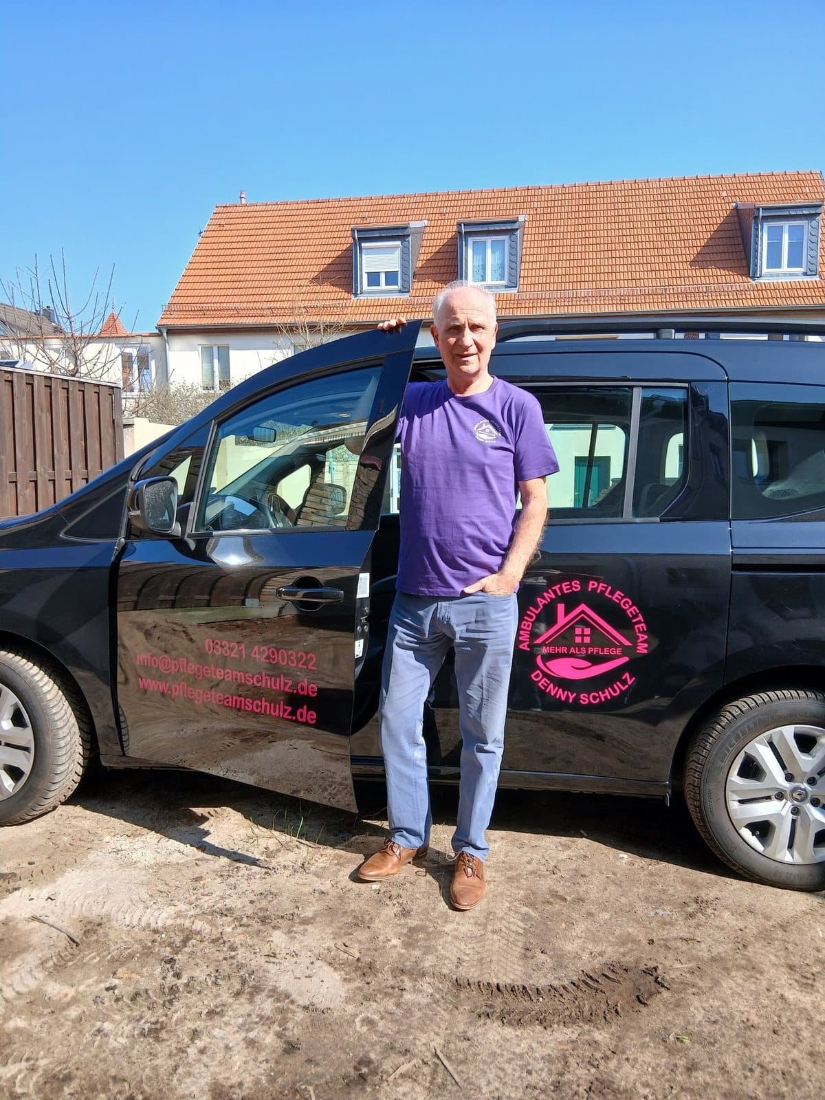 Mitarbeiter des Pflegeteams vor dem Fahrzeug des Fahrdienstes