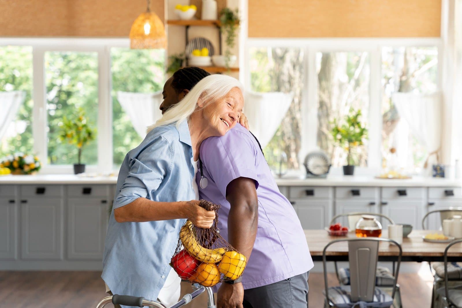 Pflegekraft bringt einer Seniorin den Einkauf in die Küche